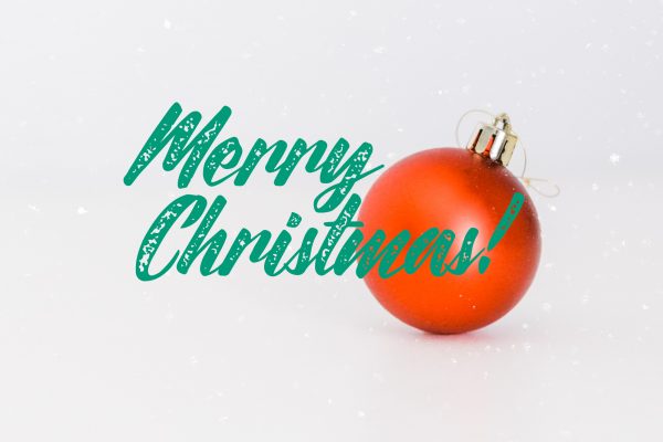 Red ornament and green text saying Merry Christmas